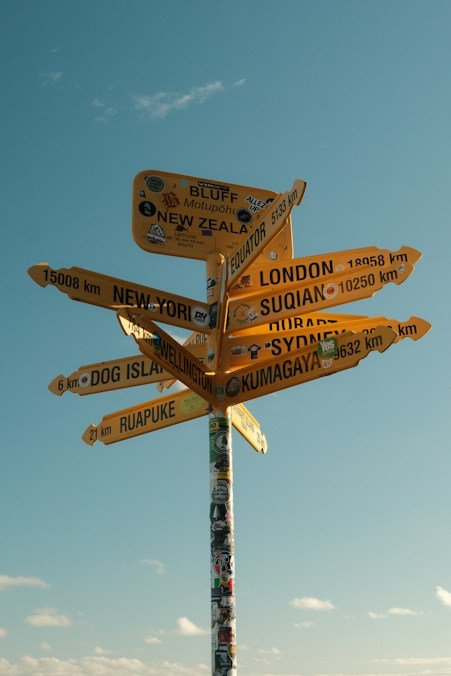 Wooden signpost pointing toward travel destinations